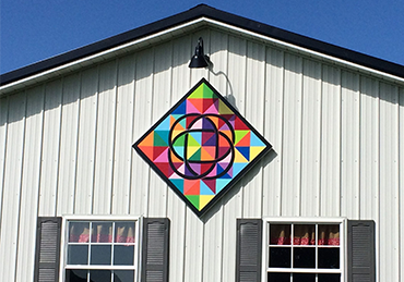 White barn with geometric quilt