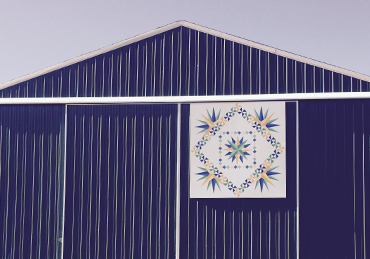 Blue barn with star burst quilt